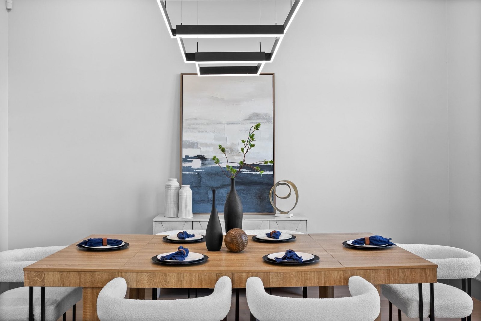 Carefully styled dining table with sculptural lighting and blue accents