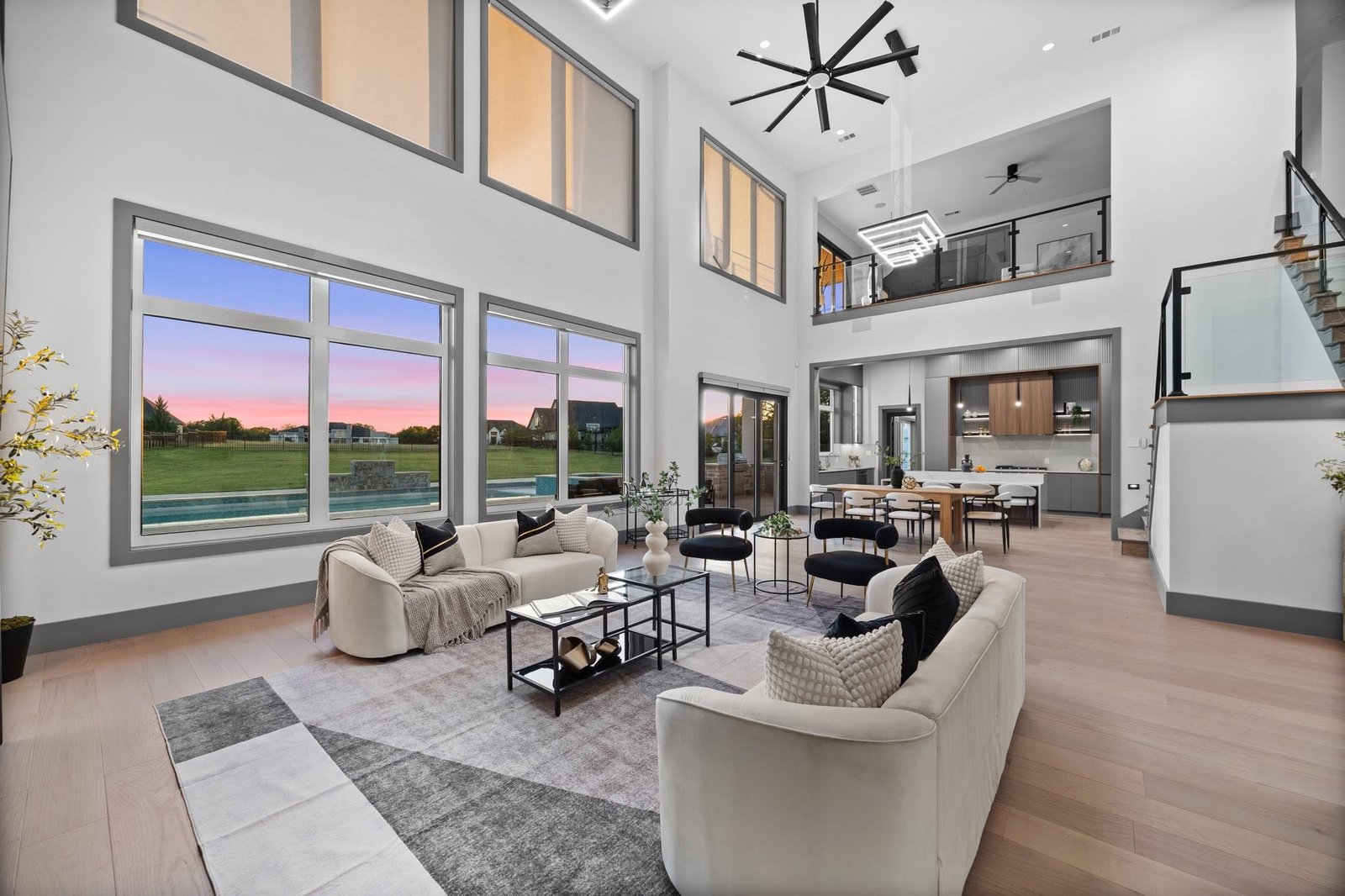 Light-filled living room with soaring ceilings, an open kitchen and a view of the pool